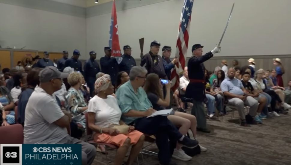 People sitting in chairs with actors in uniform at CCHC for Juneteenth reenactment.