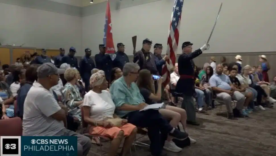 People sitting in chairs with actors in uniform at CCHC for Juneteenth reenactment.