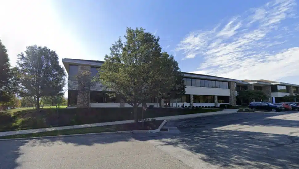 Office building with road and trees.