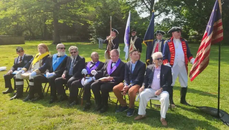 At Paoli Battlefield, re-enactors and officials sit down.