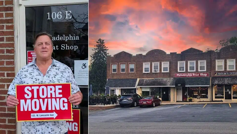 Store owner holds moving sign next to new location.