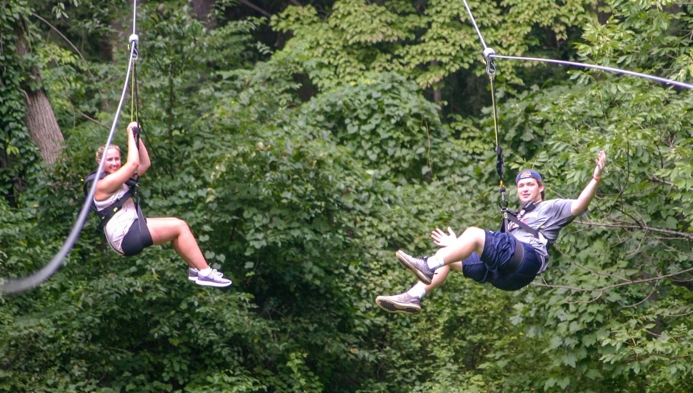 Two guests ziplining outdoors at Treehouse World.