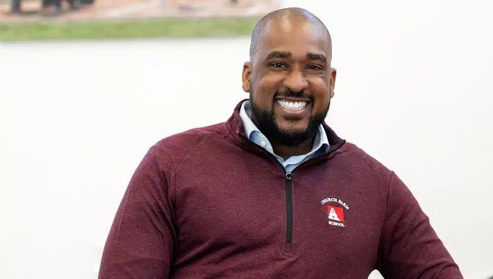 Headshot of smiling, middle-aged head of school wearing maroon sweater.