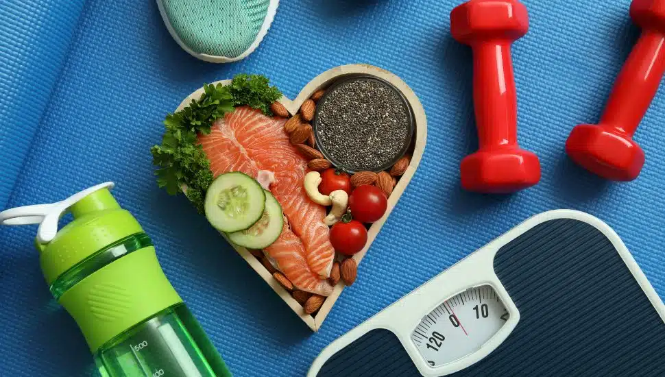 Healthy lifestyle concept with water bottle, healthy food, and exercise equipment.
