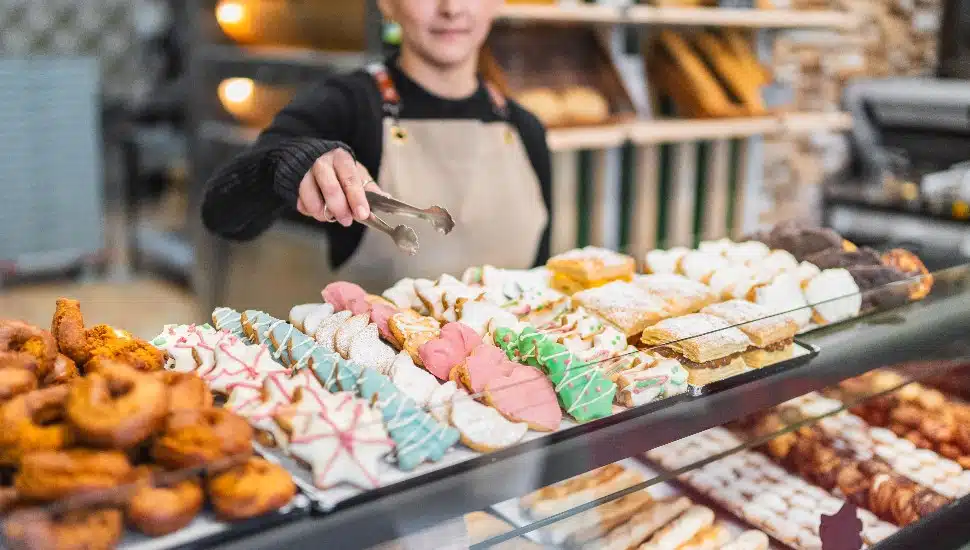 A team member arranging cookies at a bakery.