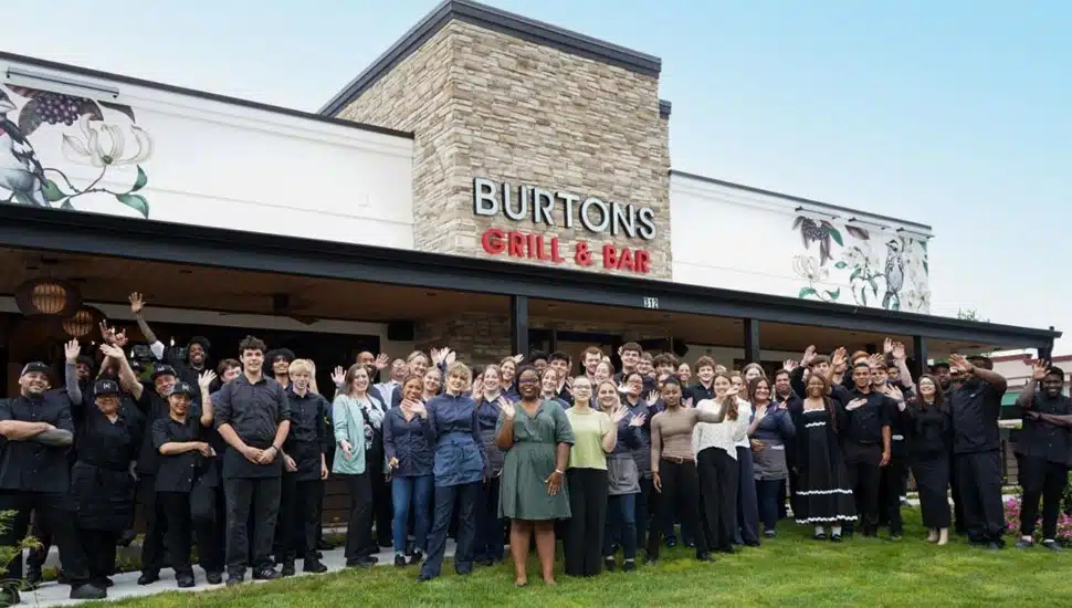 Staff in a group in front of Burtons Grill & Bar for opening.