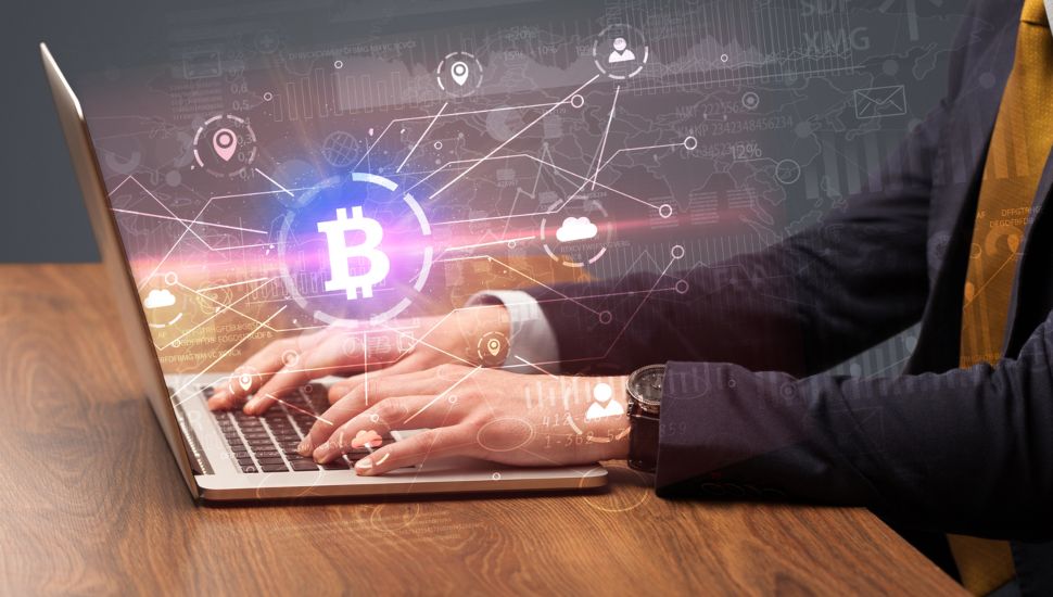 bitcoin symbol with person on laptop