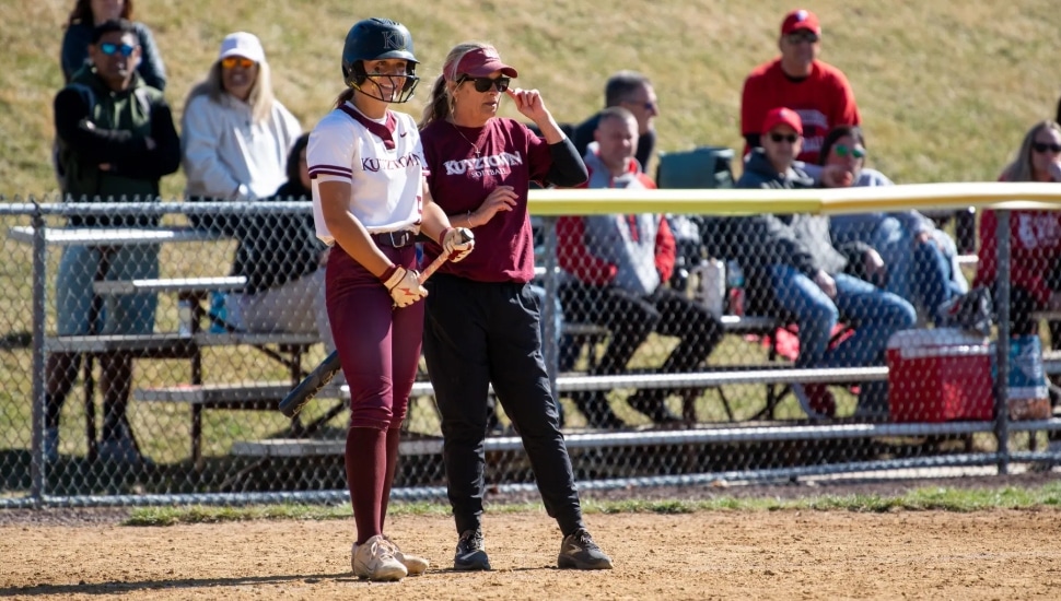 Kutztown softball coach Judy Lawes with a player during a Kutztown softball game.