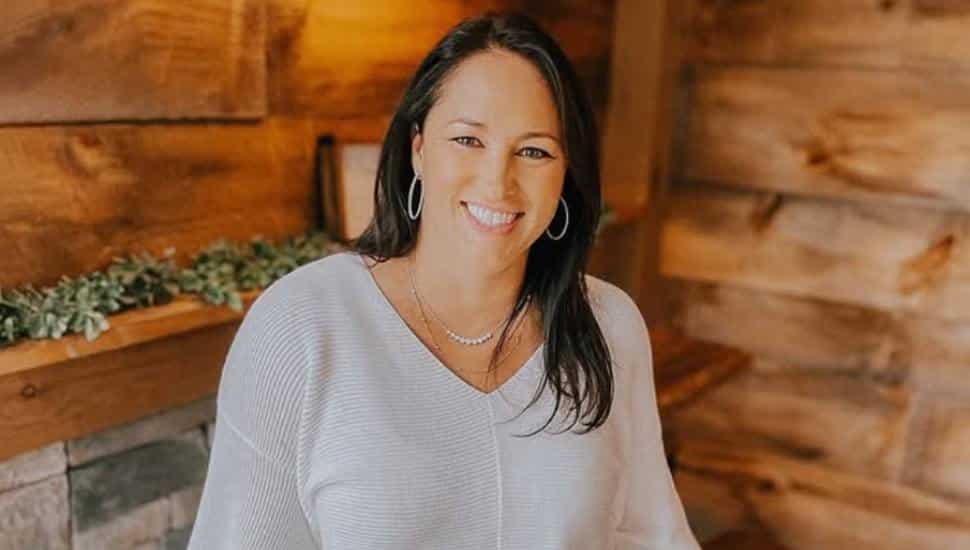 Kathy Romano headshot with wood background.