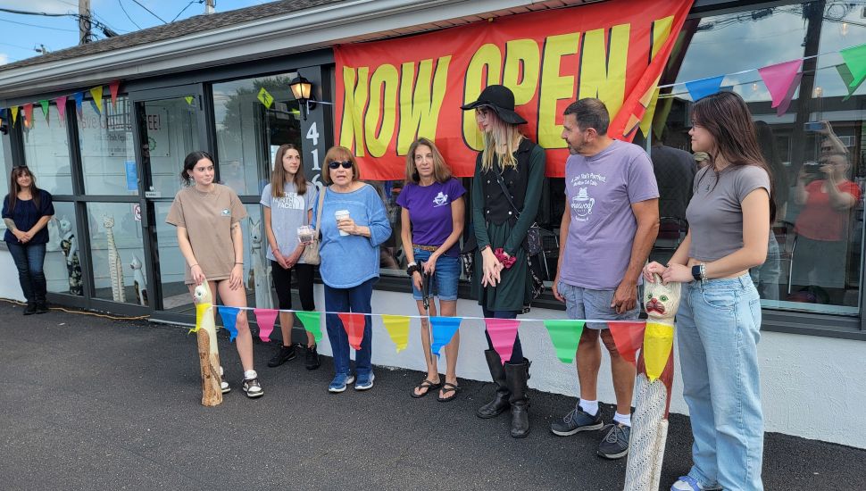 The owner and workers at the MeWow Cat Cafe's grand opening preparing to cut the ribbon.