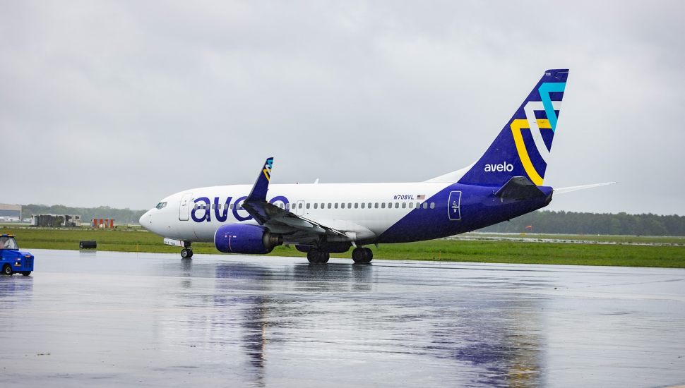 Avelo plane on tarmac in rainy weather.