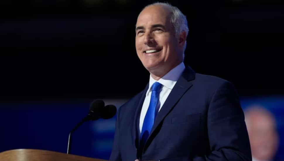 Bob Casey smiles at podium in navy suit.