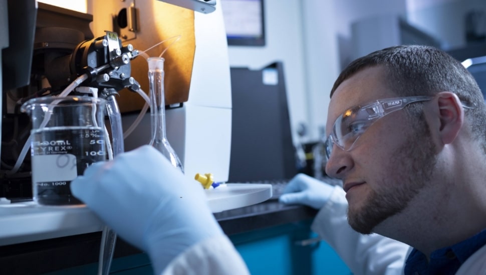 Man working in lab wearing lab glasses.