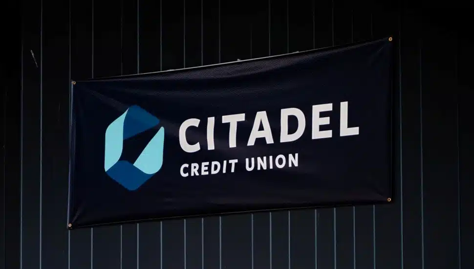 Banner with bank signage hangs on curtain.