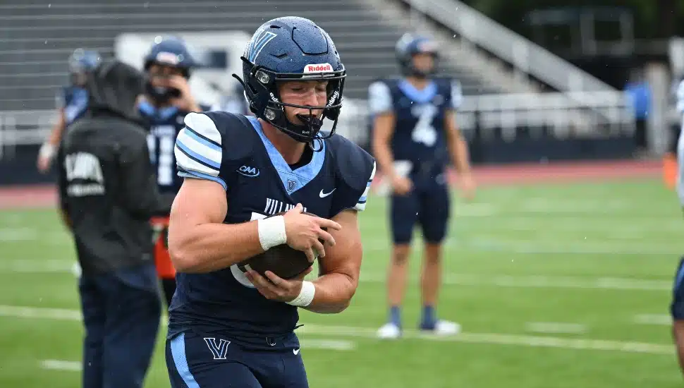 Football player secures the ball in practice.