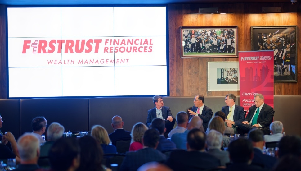Panelists discuss market in front of audience.