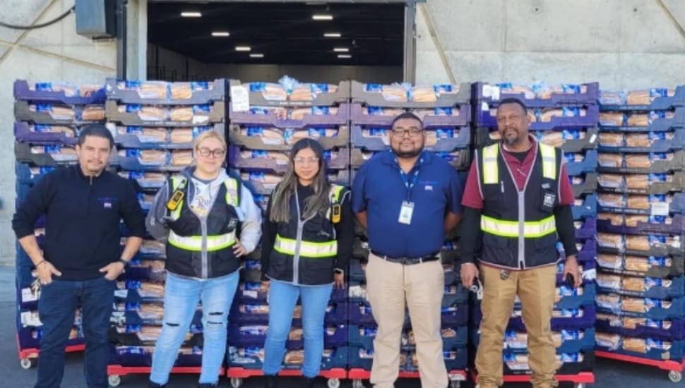 Grupo Bimbo employees with baking supplies behind them.
