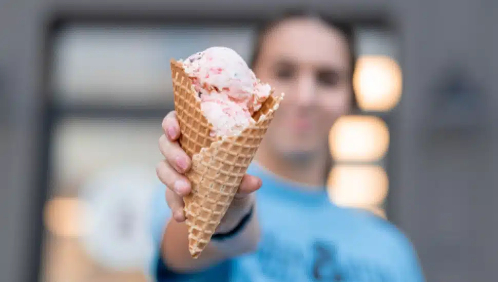 A team member holding an ice cream cone at Hangry Bear Creamery.