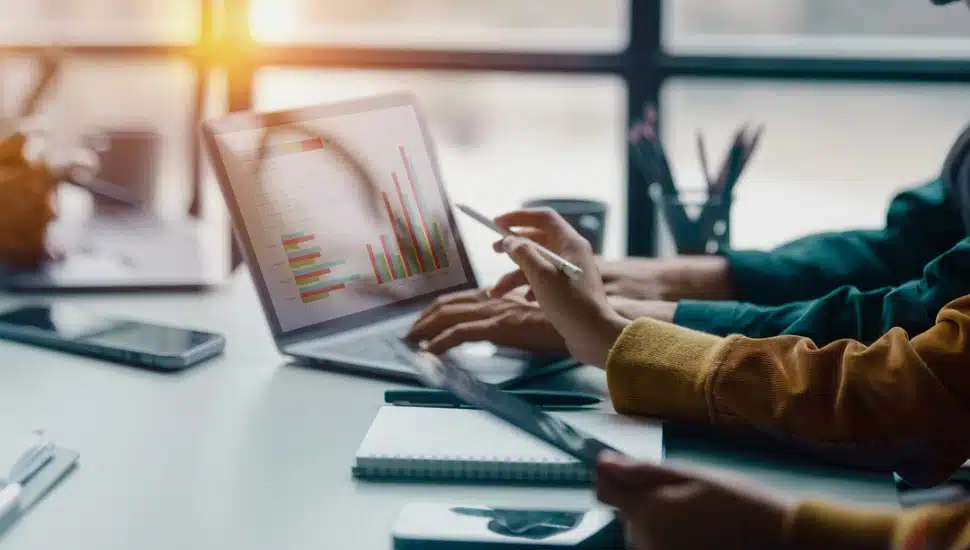 Two marketing professionals alongside a computer and work materials.