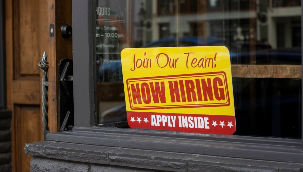 Now Hiring sign on window.