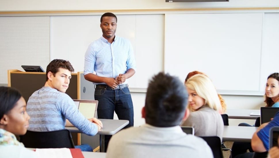 Male teacher in a classroom full of students.