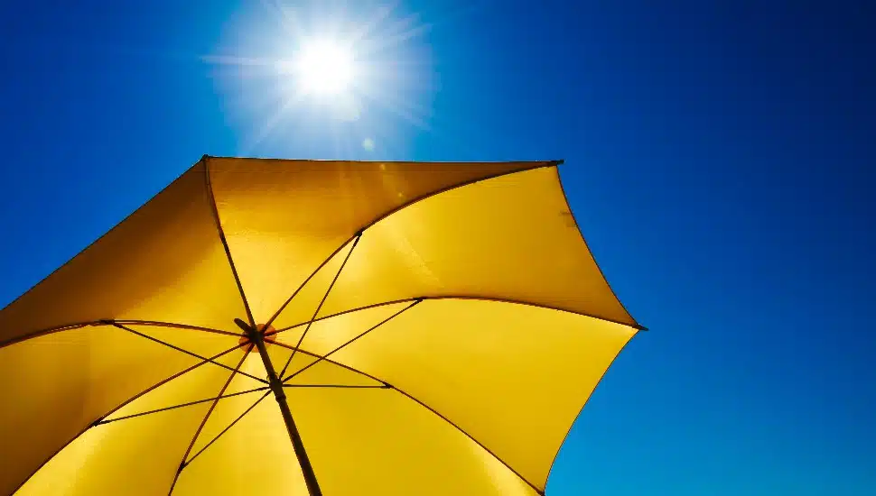 A yellow umbrella against a bright summer sky.