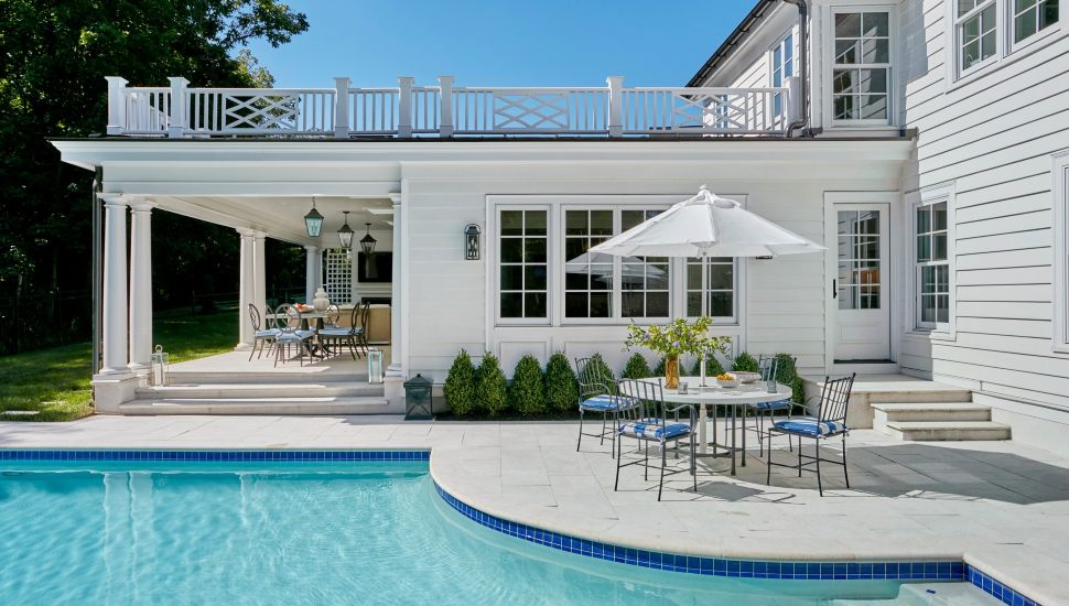 Wayne reno with white exterior, blue accents, and a turquoise pool.