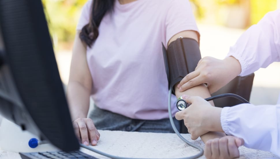 A woman receives a free blood pressure screening at a community health fair.