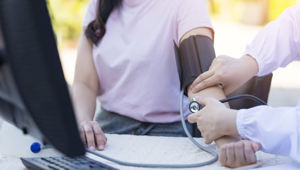 Doctor taking blood pressure on patient.