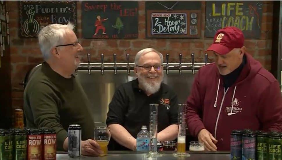 Three men smiling and talking over drinks at Barnaby’s Restaurant during West Chester University’s Science on Tap program, which pairs engaging science presentations with a casual pub atmosphere.