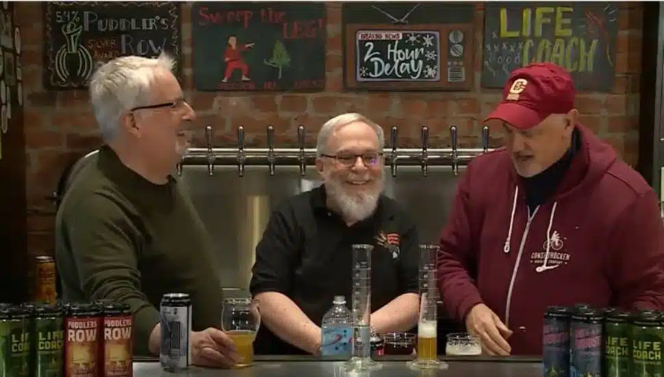Three men smiling and talking over drinks at Barnaby’s Restaurant during West Chester University’s Science on Tap program, which pairs engaging science presentations with a casual pub atmosphere.
