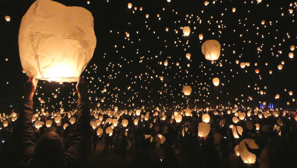 Crowds of people releasing lanterns.