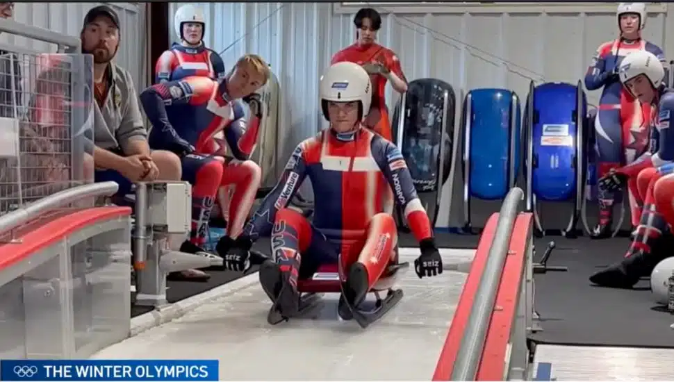 Athlete on luge sled preparing to go down track.
