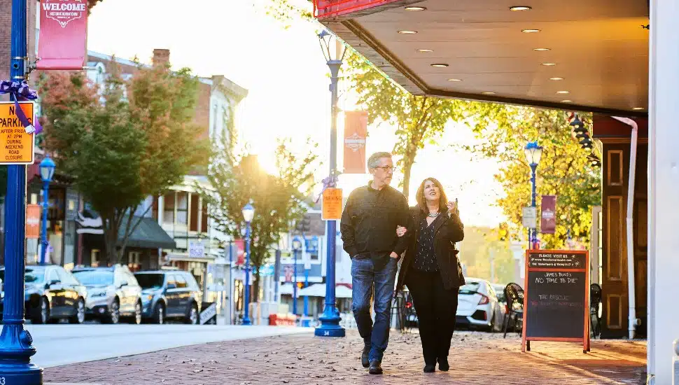 Two visitors walking down a main street in downtown Phoenixville.