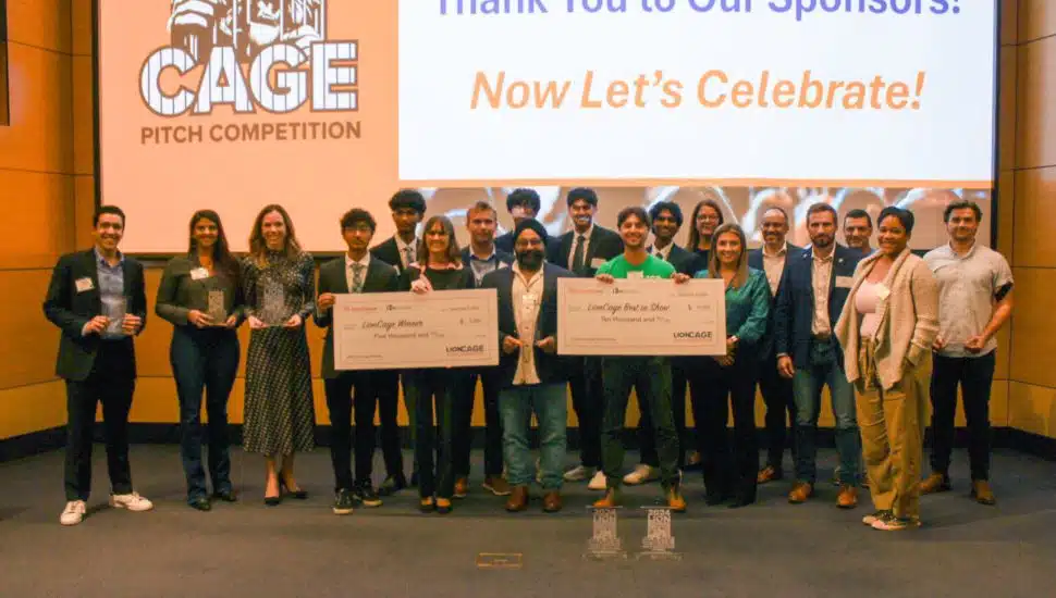 Group of people with giant checks at LionCage Pitch Competition.