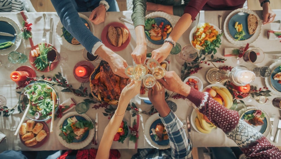 A holiday toast above a festive holiday table setup.
