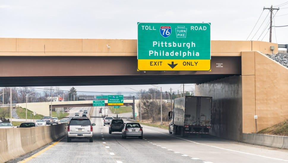 An exit sign and traveling cars along the Pennsylvania Turnpike.