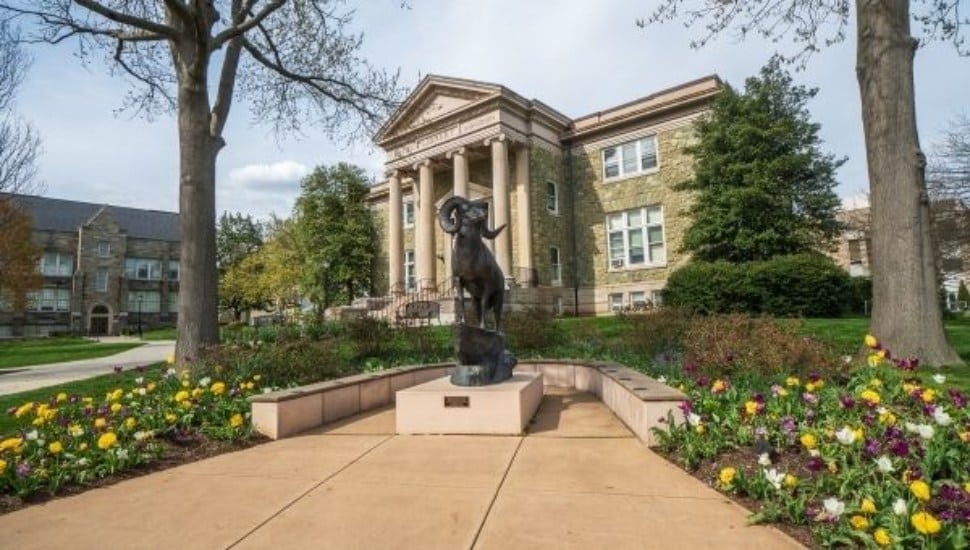 The exterior of a campus building and an outdoor ram statue at West Chester University.