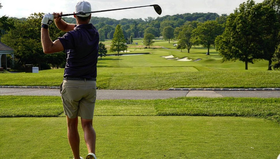 Man hitting golf ball at Waynesborough Country Club.