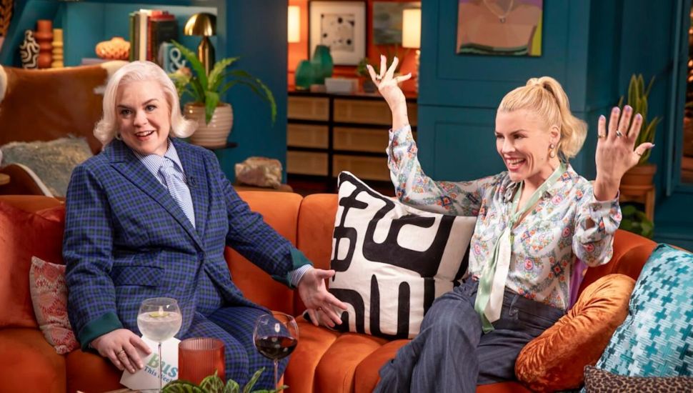 Caissie St. Onge and Busy Philipps on an orange couch.