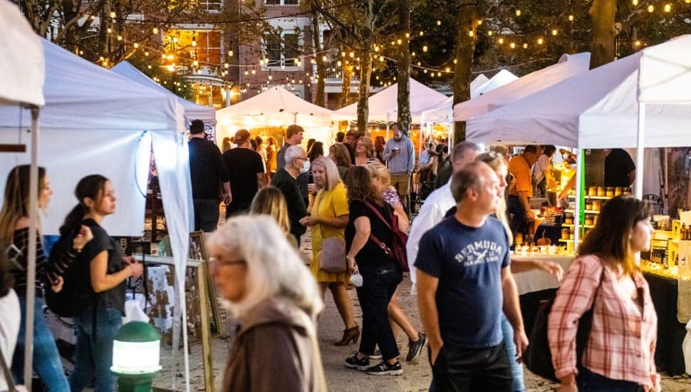 Crowds enjoying an evening outdoor market at Eagleview Town Center with vendor tents, string lights, and community members shopping and socializing.