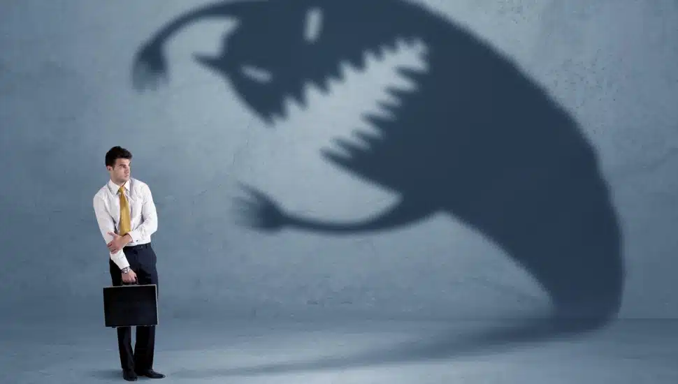 Businessman afraid of his own shadow monster.