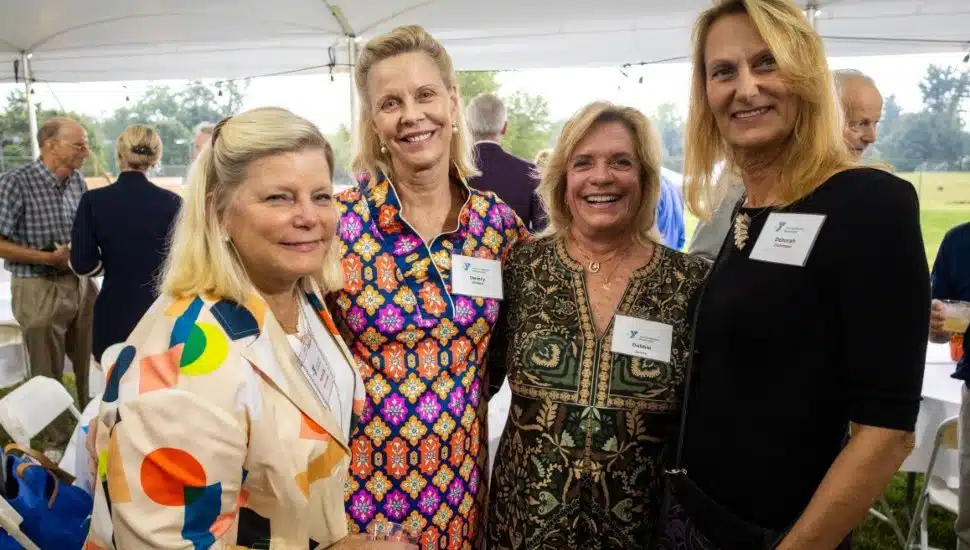Four women smiling together at the YMCA of Greater Brandywine’s dedication event for the Robert B. Jones Memorial Pool, celebrating community, generosity, and the legacy of giving.