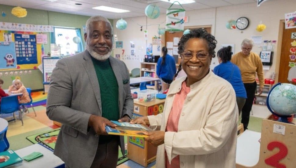 Rev. Dr. Richelle Foreman-Gunter of the West Chester NAACP presents children’s books to Bertram L. Lawson II, President and CEO of the YMCA of Greater Brandywine, during a community book donation event at a YMCA childcare center.