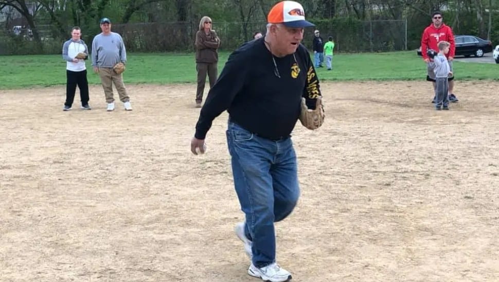 Coach Jack Malone wearing baseball glove on mound.