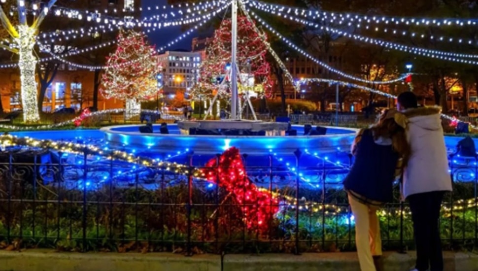 Couple look at holiday light show in winter.