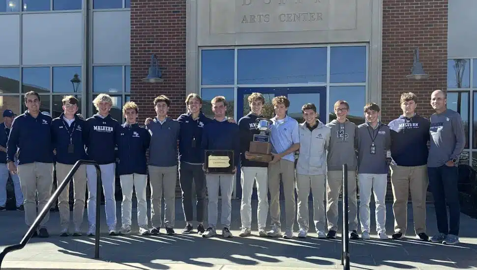 Members of the 2025 Malvern Prep golf and cross country teams with a celebratory plaque and trophy.