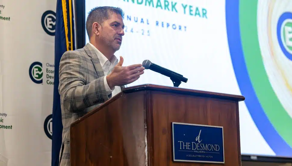 Mike Grigalonis at podium with powerpoint in background.