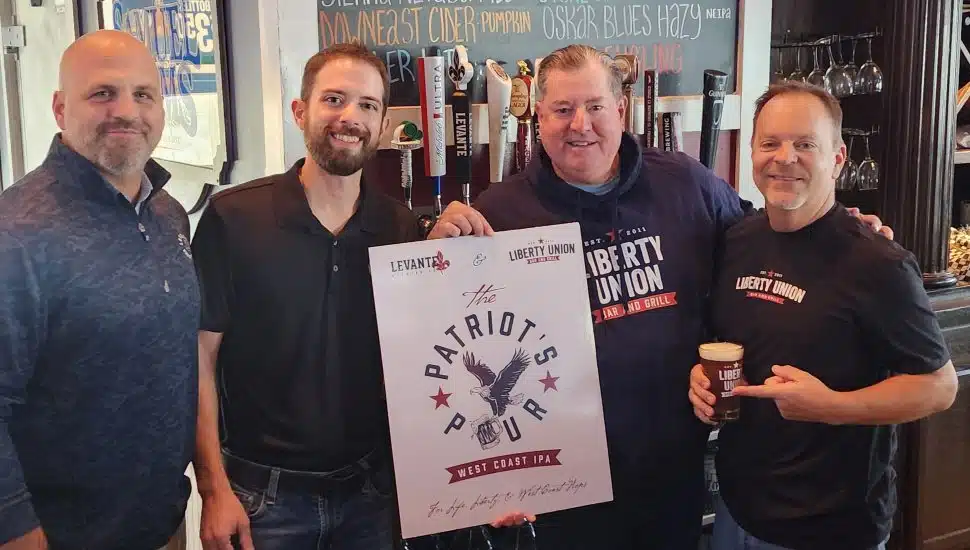 Liberty Union Bar & Grill and Levante Brewing partners holding The Patriot's Pour signage.