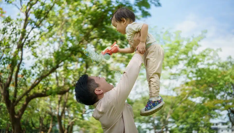 Father lifts small son into the air.